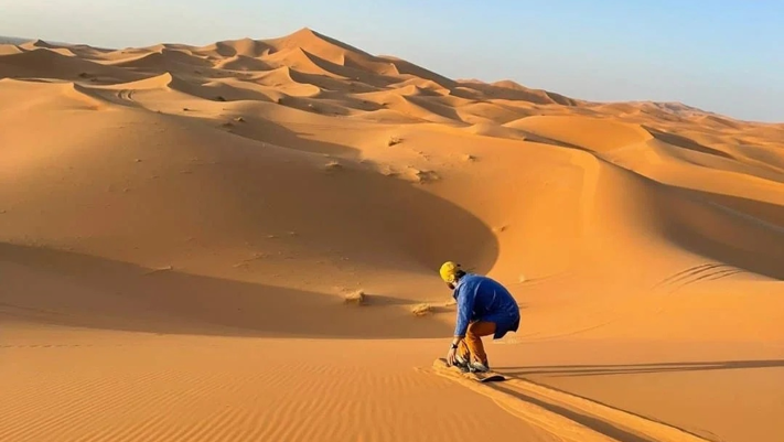 Sandboard dans le dunes se l'erg Chebbi, près de Merzouga